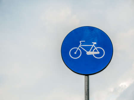 Street or road sign with a bicycle. Bicycle sign with cloudy sky as background.の写真素材
