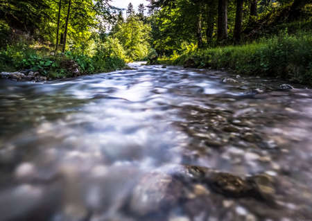 Stream flowing smoothly between rocks in the mountains.の写真素材