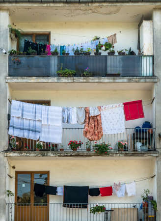 Old worn out communist apartment bulding in Bucharest, Romania. Laundry left to dry on the balcony.の写真素材