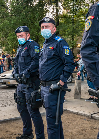 Bucharest/Romania - 09.19.2020: Police officers and Gendarmerie or military police closely supervising the demonstrators from University square who gathered to protest against wearing face masks in schools.のeditorial素材