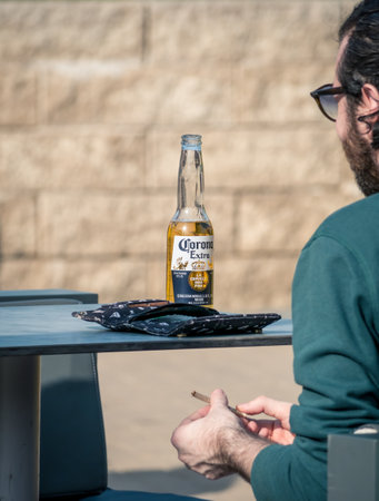 Bucharest/Romania - 09.19.2020: A bootle of Corona extra pale lager beer on a table. Man having a beer on a nice day .のeditorial素材