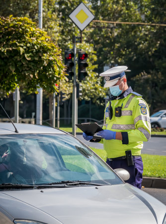 Bucharest/Romania - 10.17.2020: Traffic police officer writing a ticket to a female driver who broke the law.のeditorial素材