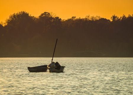 Two abandoned fishing boats in the middle of a lake at sunset..の写真素材