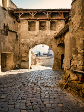 Cobblestone street between the walls of Sighisoara fortress in Romania.の写真素材