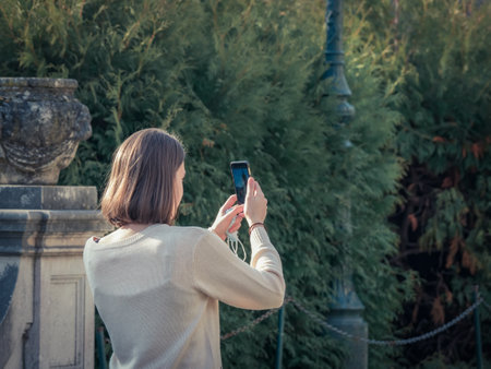 Sinaia Romania - 12.02.2020: Tourist girl taking a picture with her smartphone at Peles Castle in Sinaia.のeditorial素材