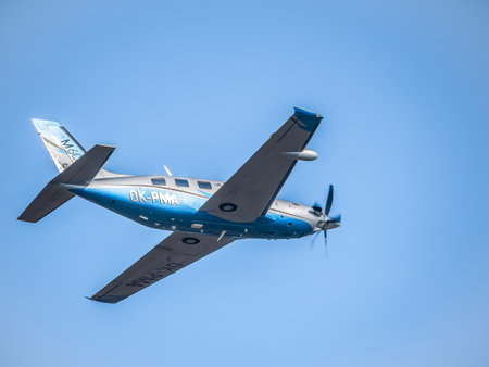 Otopeni, Romania - 01.23.2021: Light aircraft Piper PA-46-600TP (M600), belonging to OK Aviation Group, flying against blue skyのeditorial素材
