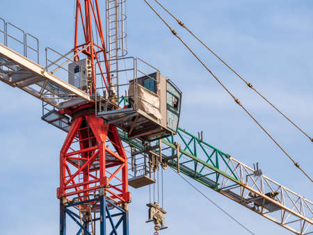 Close up details with a cabin control of a construction crane.Turret Slewing Crane against blue skyの写真素材