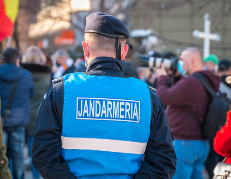 Bucharest, Romania - 03.14.2020: Police officers and Gendarmerie or military police closely supervising the demonstrators from University square at the protest against anti covid vaccine and coronavirus restrictions.のeditorial素材