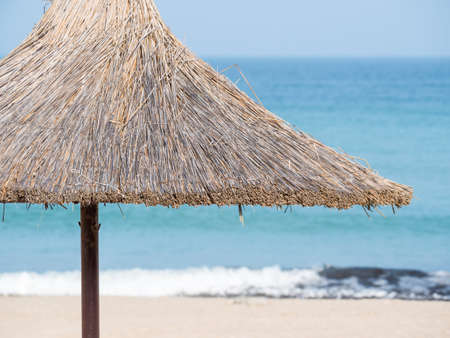 Summer landscape with straw umbrellas on the beach in Mangalia or Mamaia. Beach at the Black Sea in Romania.の写真素材