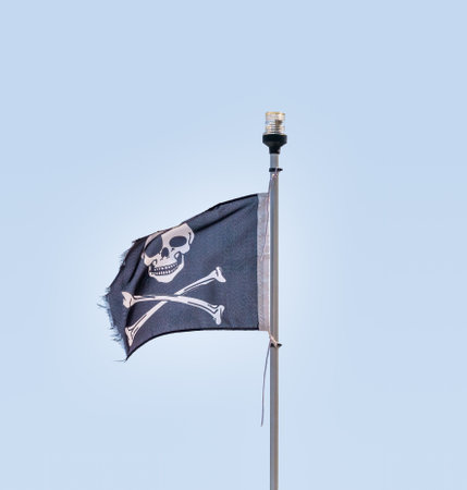 Pirate flag with a skull and two crossed bones in the wind,の写真素材