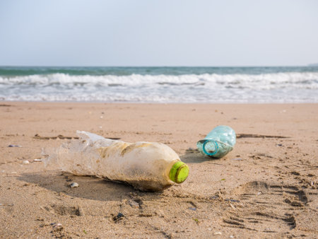A PET plastic bottle left on the sandy beach. Plastic pollution environment concept.の写真素材