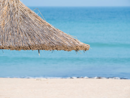 Summer landscape with straw umbrellas on the beach in Mangalia or Mamaia. Beach at the Black Sea in Romania.の写真素材