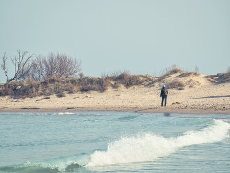 Man or woman having a walk or strolling on the beach.の写真素材