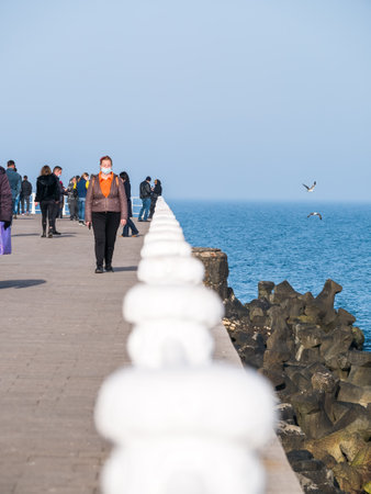 Constanta, Romania - 02.25.2021: People strolling or walking on Constanta seafront (Faleza Cazino Constanta).のeditorial素材