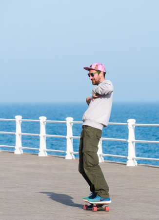 Constanta, Romania - 02.25.2021: Happy young man on a skateboard doing tricks on Constanta Seafront (Faleza Constanta),のeditorial素材