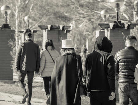Black and white back view with people walking in the park.の写真素材
