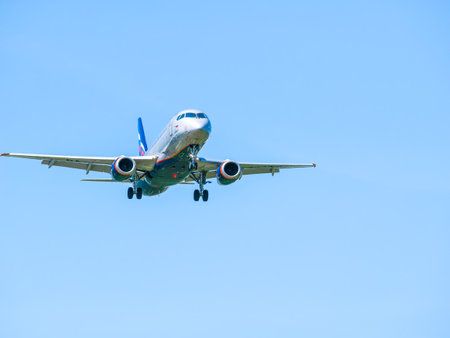 Otopeni, Romania - 05.08.2021: Aeroflot Sukhoi Superjet 100-95B flying against blue sky. Airplane arriving at Henry Coanda International Airport.のeditorial素材
