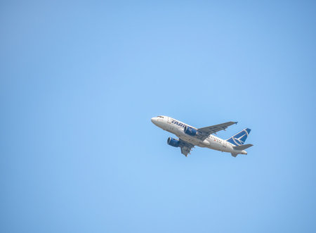 Bucharest, Romania - 04.29.2021: Tarom Airbus A318-111 (YR-ASC) airplane flying against blue sky.のeditorial素材