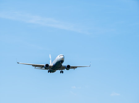 Otopeni, Romania - 05.08.2021: Blue Air Boeing 737-82R (YR-BMK) flying against blue sky. Airplane arriving at Henry Coanda International Airport.のeditorial素材