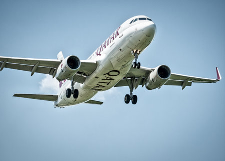 Otopeni, Romania - 05.08.2021: Qatar Airways Airbus A320-232 (A7-AHT) flying against blue sky. Airplane arriving at Henry Coanda International Airport.のeditorial素材