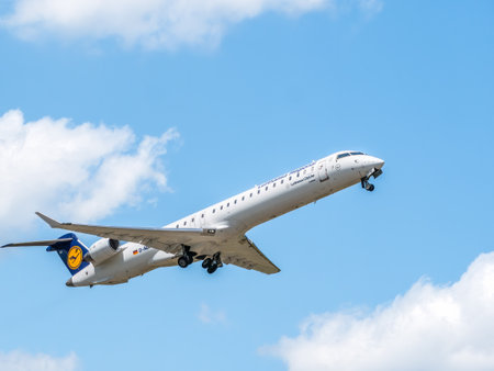 Bucharest, Romania - 05.14.2021: Lufthansa CityLine D-ACKI Mitsubishi CRJ-900LR airplane flying against clear blue sky. Airplane takes off from Henri Coanda International Airport.のeditorial素材