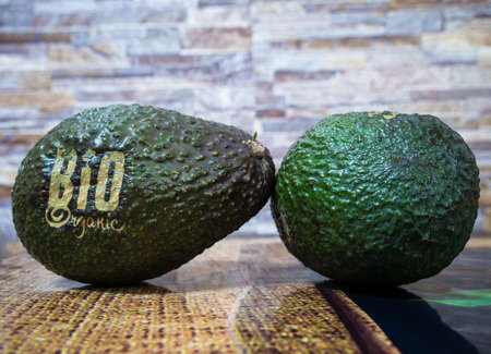 Close up detail photo with two avocado fresh organic bio fruit on the kitchen tableの写真素材