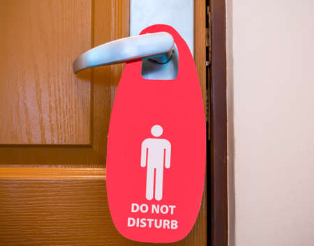 Do not disturb sign hanging on the door handle at a hotelの写真素材