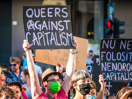 Bucharest, Romania - 08.14.2021: Many people attending at LGBTQ Pride parade rally and displaying a banner with the words "Queers against capitalism""のeditorial素材