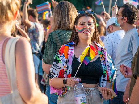 Bucharest, Romania - 08.14.2021: Beautiful girl with a septum piercing ring and the rainbow flag painted on her face at LGBTQ Pride parade rally .のeditorial素材