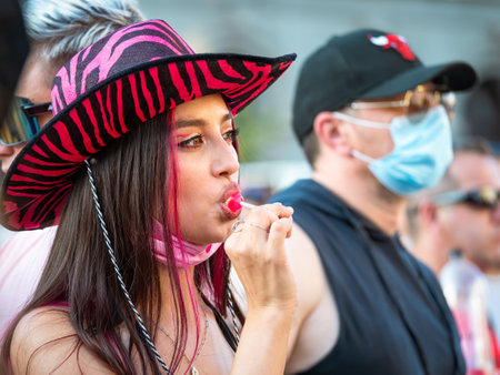 Bucharest, Romania - 08.14.2021: Beautiful girl with a pink hat and a lollipop between her lips at LGBTQ Pride parade rally .のeditorial素材