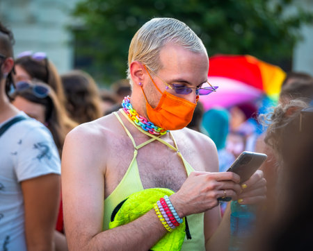 Bucharest, Romania - 08.14.2021: Man looking at his smartphone at LGBTQ Pride parade rally .のeditorial素材