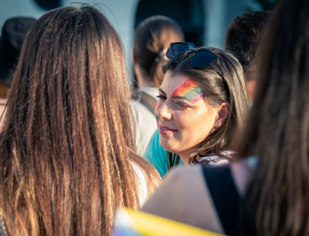 Bucharest, Romania - 08.14.2021: Beautiful girl with a septum piercing ring and the rainbow flag painted on her face at LGBTQ Pride parade rally .のeditorial素材