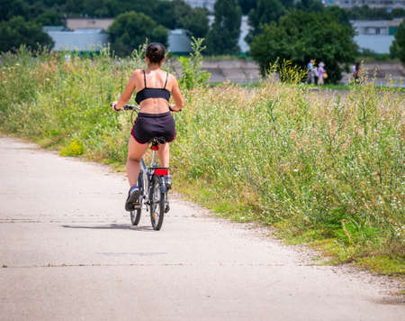 Fit woman exercising and riding a bicycle in natureの写真素材
