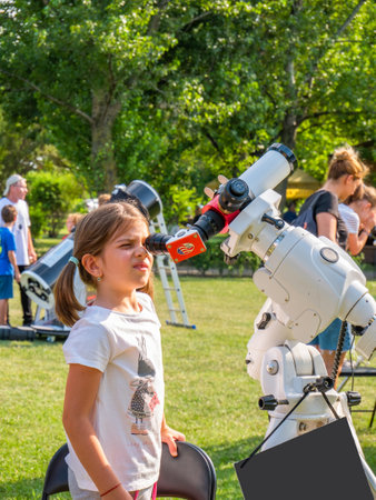 Bucharest, Romania - 07.23.2021: Young girl looking through a microscope at the sky during a Astronomy festivalのeditorial素材