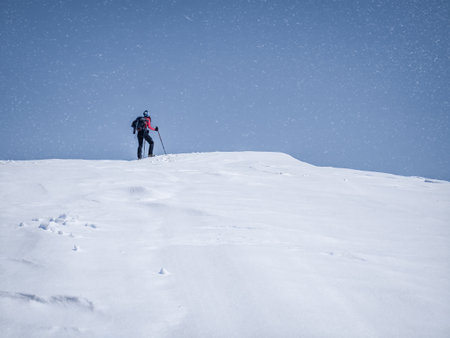 Winter landscape with a hiker taking a break to look at the snowfallの写真素材