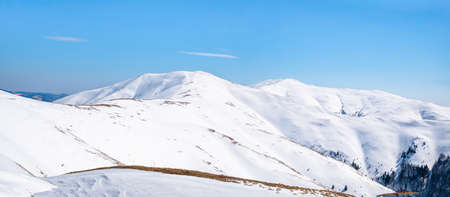 Detail with a mountain covered in white snow against clear blue sky. Panoramic viewの写真素材