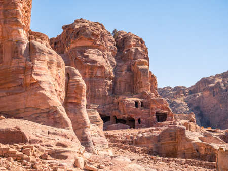 Ancient housing carved in red sand rock in the city of Petra, Jordan.の写真素材
