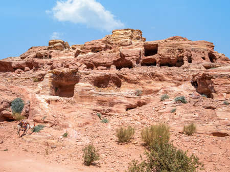 Ancient housing carved in red sand rock in the city of Petra, Jordan. Rocky landscape from Petra, Jordan.の写真素材