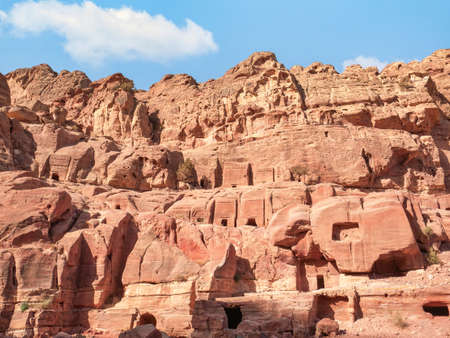 Ancient housing carved in red sand rock in the city of Petra, Jordan. Detail with Tomb of 'Unayshuの写真素材
