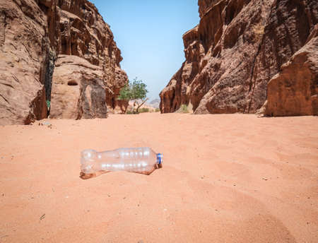 A PET plastic bottle left in the Wadi Rum desert, Jordan. Plastic pollution environment concept.の写真素材