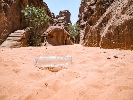 A PET plastic bottle left in the Wadi Rum desert, Jordan. Plastic pollution environment concept.の写真素材