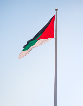 Jordanian flag waving in the wind against blue sky.の写真素材