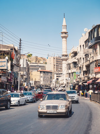 Amman, Jordan - 09.02.2021: Cars on the streets of Amman and the Grand Husseini Mosque in the background.のeditorial素材
