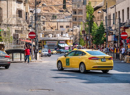 Amman, Jordan - 09.02.2021: Yellow taxi cab on the busy streets of Amman, the capital of Jordan.のeditorial素材