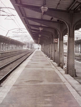 Lonely moody scene with an empty train station or railway platform on a foggy morning.の写真素材