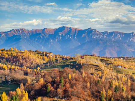 Beautiful rustic landscape in Magura village,Romania, with traditional romanian houses and Bucegi mountains in the backgroundの写真素材