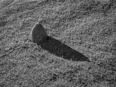 View of a Haystack on the field. Abstract minimalist rustic landscape in Magura village, Romania.の写真素材