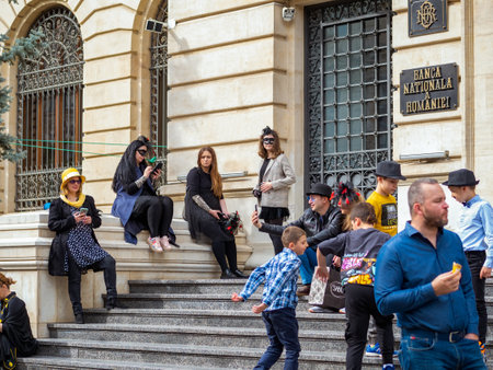 Bucharest, Romania - 04.08.2022: Many people in costumes sitting on the stairs in front of Romanian National Bank (Banca Nationala a Romaniei)のeditorial素材