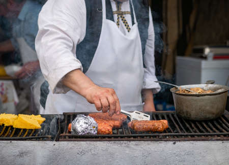 Mititei( ground meat rolls)and porridge made out of yellow maize flour (mamaliga)on the grill. Traditional romanian dishの写真素材