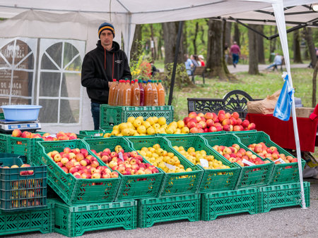 Bucharest, Romania - 04.15.2022: Street vendor selling different sorts of apples and fresh apple juice. Stall with fruits for sale.のeditorial素材